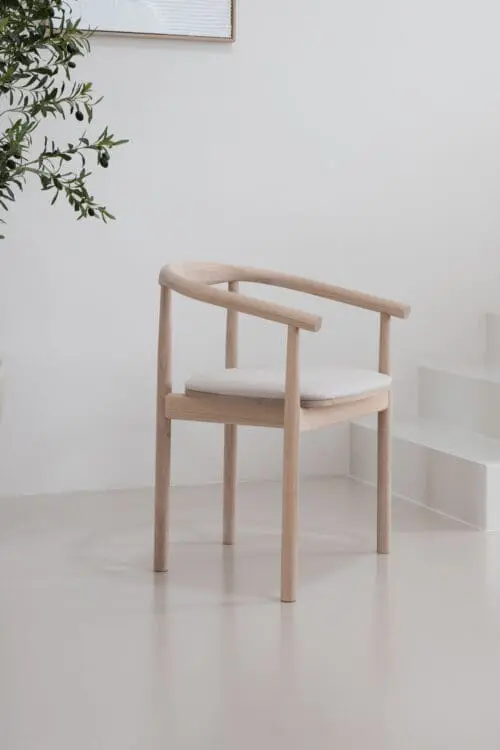Japandi Eetkamerstoel Calm met een wit eiken eikenhouten frame en creme zitting in een minimalistisch Japandi en Scandinavisch interieur.