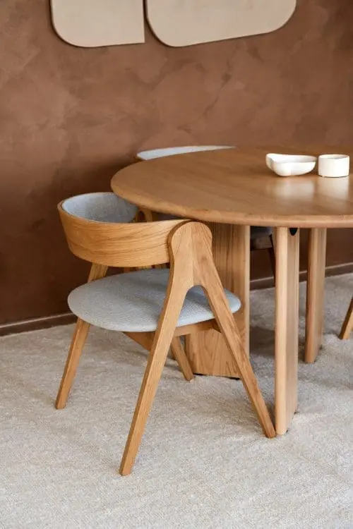 Japandi eetkamerstoel Anna met naturel houten frame en lichtblauwe stof, passend in een rustig, warm en minimalistisch Japandi interieur.